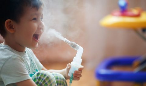 Little boy makes inhalation at home, taking medication to bronchial