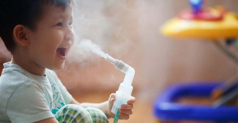 Little boy makes inhalation at home, taking medication to bronchial